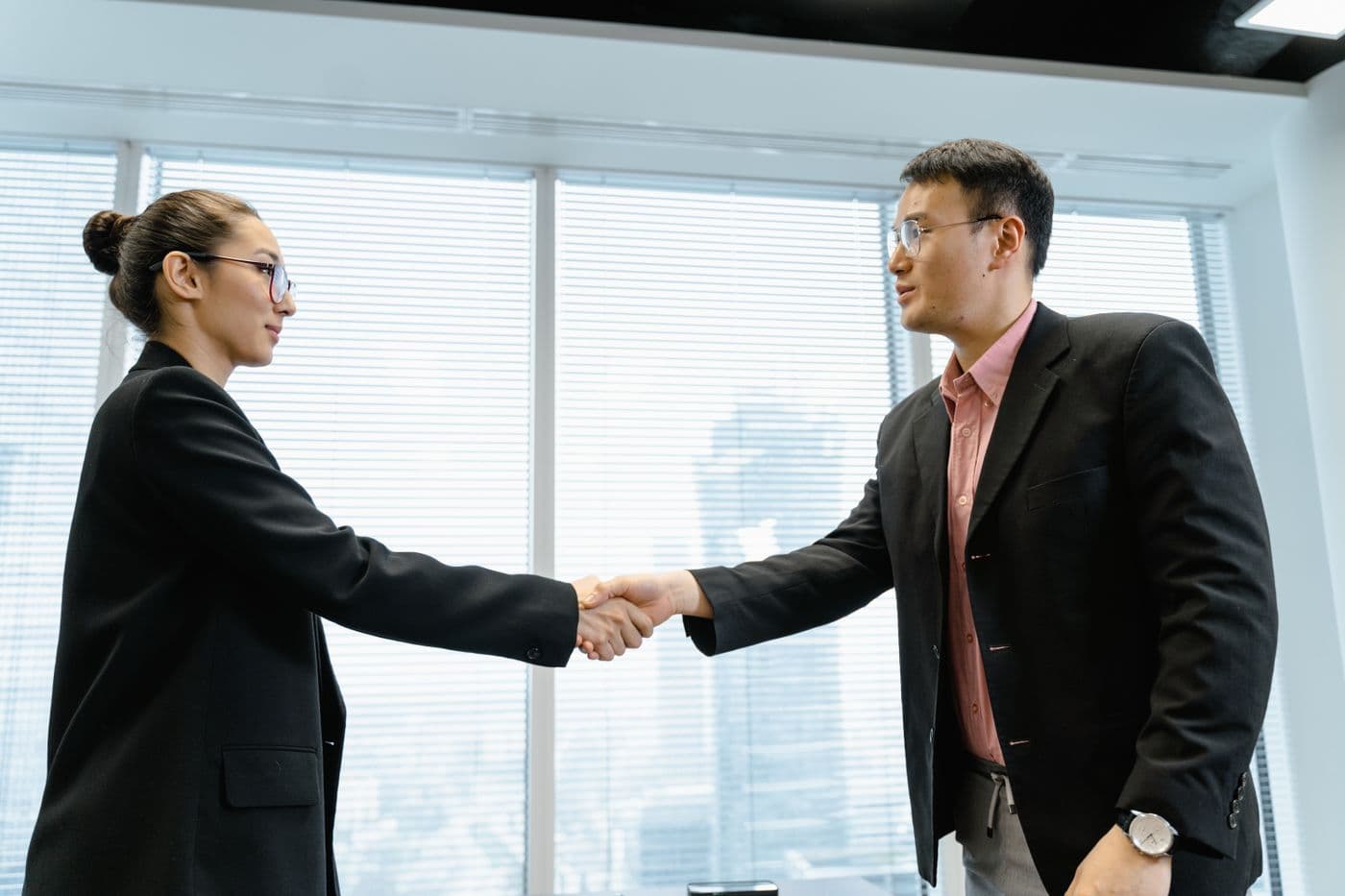 Athena Group representatives greeting a partner in a modern office